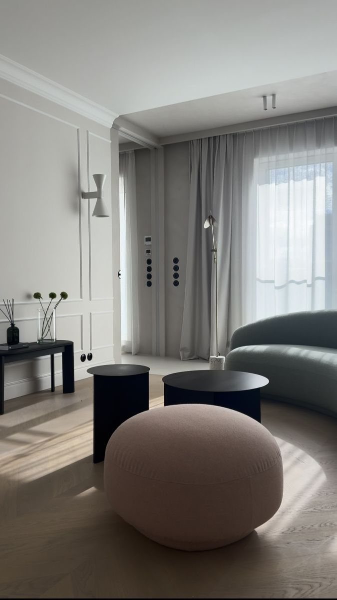Salon z sofą i pufą, jasne zasłony do sufitu